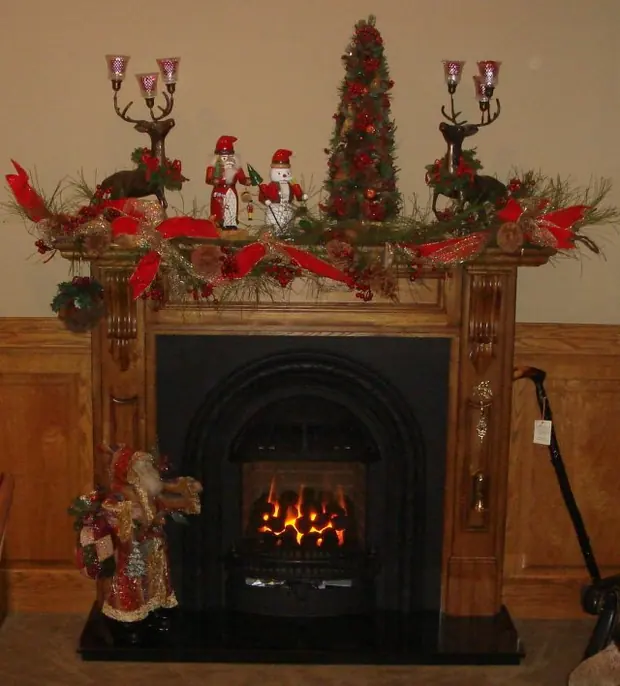 Gas coal fireplace insert with a live fire under a timber mantel decorated for Christmas