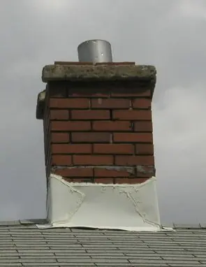 Rebuilt brick chimney topped with a stainless steel chimney cover