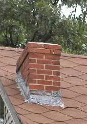 Brick chimney raised to the correct height above a pitched roof