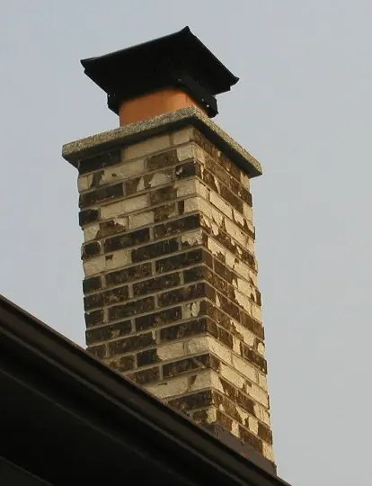 Brick chimney rebuilt above the roof line with a new concrete crown