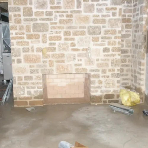 Newly built stone fireplace with a firebrick firebox in an unfinished room